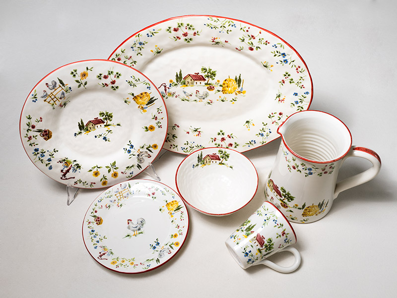 Fattoria Line Mastrogiorgio collection in Italian handcrafted ceramics, plates and cups decorated with colorful country scenes.